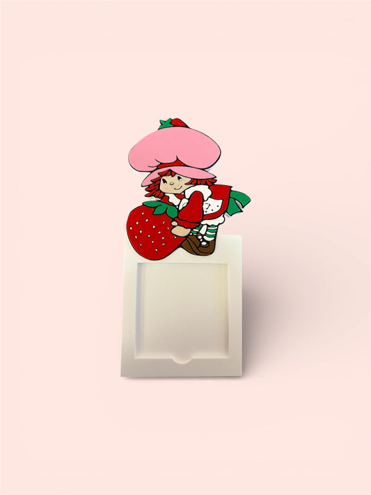 Strawberry shortcake holding strawberry sticky note holder